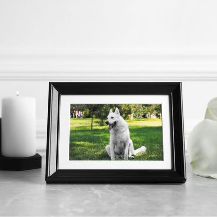 A photo of a dog on a table with candles and lilies