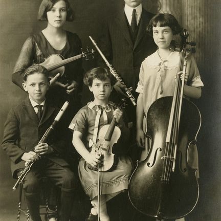 An old photo of a family of young musicians holding their instruments