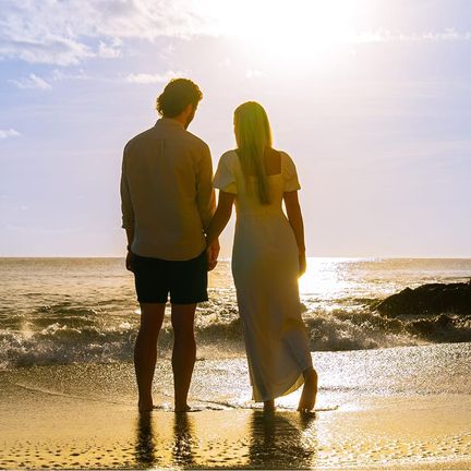 A couple on a beach during their honeymoon