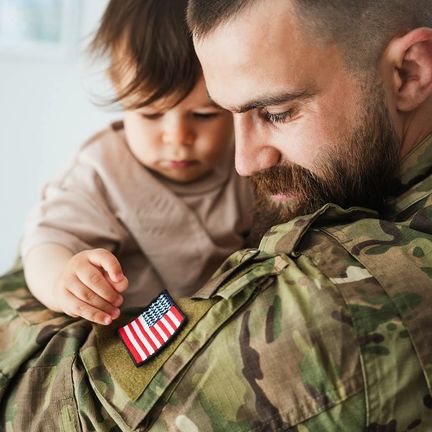 A man in a US service uniform holds his small son